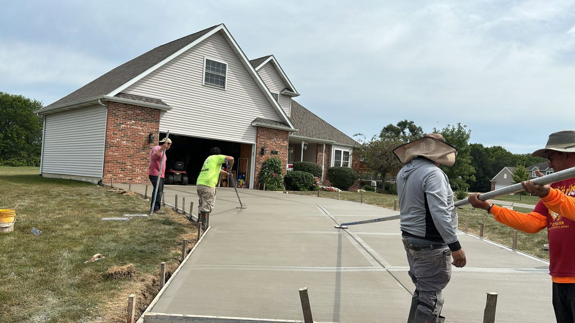 Fredd Construction crew finishing a residential concrete driveway